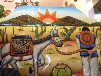 Art is on table tops and over booth back rests